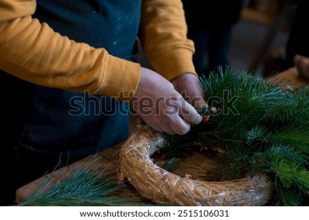straw round base, scissors and green twigs components in human hands in action