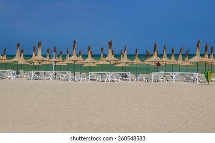 Straw Umbrellas On The Black Sea Beach In Romania