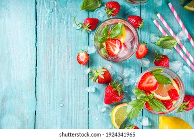 Strawberries and basil lemonade. Summer cold iced cocktail recipe, with fresh strawberry, lemon and basil leaves, wooden background copy space