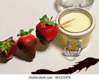 strawberries with custard in glass and chocolate