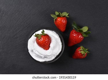 Strawberries On Whipped Cream On Black Background