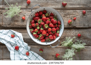 Strawberries on a wooden background in a colander. Rustic style photo with strawberries.