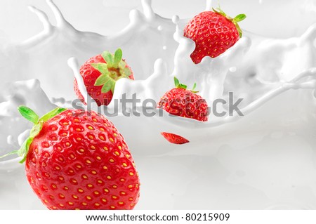 Strawberries splashing in to milk