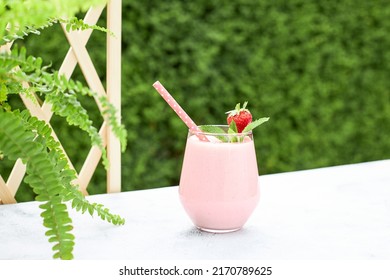 Strawberry banana milkshake or smoothie garnished with a strawberry and a mint leaf. Refreshing summer soft drink. Healthy food concept. - Powered by Shutterstock