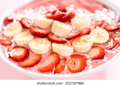 Strawberry And Banana Smoothie Bowl Garnished With Coconut Flakes And Fresh Fruits.