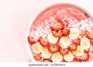 Strawberry And Banana Smoothie Bowl Garnished With Coconut Flakes And Fresh Fruits.