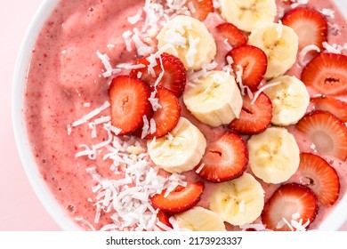 Strawberry And Banana Smoothie Bowl Garnished With Coconut Flakes And Fresh Fruits.