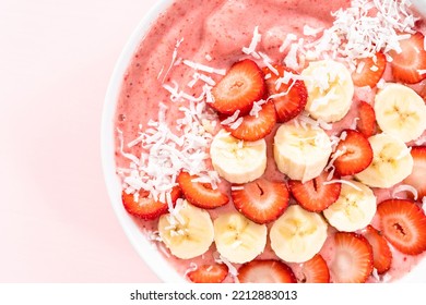 Strawberry And Banana Smoothie Bowl Garnished With Coconut Flakes And Fresh Fruits.