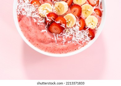 Strawberry And Banana Smoothie Bowl Garnished With Coconut Flakes And Fresh Fruits.