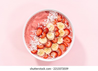 Strawberry And Banana Smoothie Bowl Garnished With Coconut Flakes And Fresh Fruits.