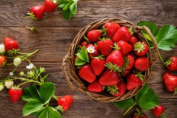 Strawberry In Basket With Twigs And Leaves On Rustic Wooden Table Closeup