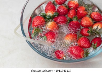 Strawberry In A Bowl With Water With A Round Ozonating Stone. Tubes Leading To Oxygen Pump And Ozone Generator. Ozonation Fruit. Food Disinfection With Ozon