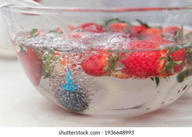 Strawberry In A Bowl With Water With A Round Ozonating Stone. Tubes Leading To Oxygen Pump And Ozone Generator. Ozonation Fruit. Food Disinfection With Ozon