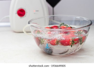 Strawberry In A Bowl With Water With A Round Ozonating Stone. Tubes Leading To Oxygen Pump And Ozone Generator. Ozonation Fruit. Food Disinfection With Ozon