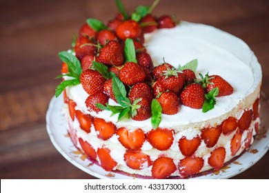 Strawberry cake on a wooden background.