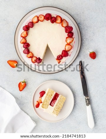 Strawberry cake, strawberry sponge cake with fresh strawberries and sour cream on a white background. Top view