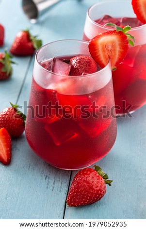 Strawberry cocktail in glass on blue wooden table