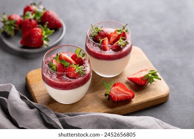 Strawberry and cream panna cotta in glasses with fresh berries on a wooden board on a gray background with napkin. Traditional Italian sweet dessert concept. Copy space. - Powered by Shutterstock