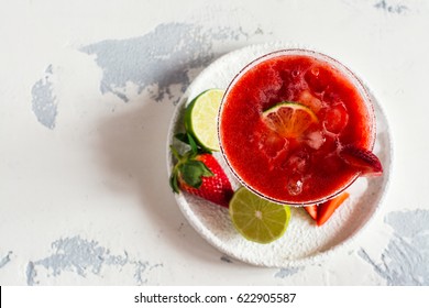 Strawberry daiquiri cocktail with lime and ice cubes. Space for text. Top view
