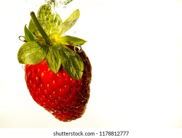 Strawberry dropped into liquid for artistic shot