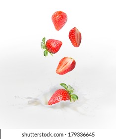 Strawberry falling into splashing milk or yogurt.