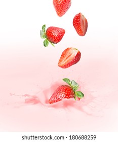 Strawberry falling into splashing milk or yogurt.