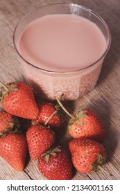 Strawberry Flavored Milk In Clear Glass On Wooden Background