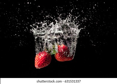 Strawberry fruit creating a beautiful splash underwater with black background - Powered by Shutterstock