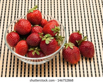 Strawberry in a glass vase on a wattled mat