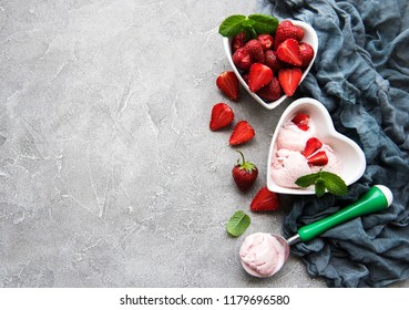 Strawberry ice cream and waffle cone on a stone background