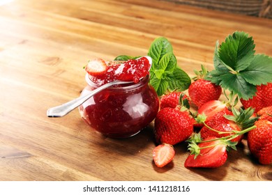 strawberry jam with fresh strawberries and mint. marmalade on spoon and jar on wood