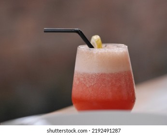 Strawberry Juice In Clear Glass Cup With Black Straw On Blur Background