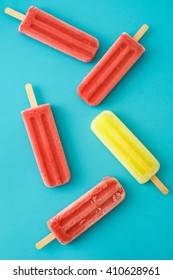 Strawberry And Lemon Popsicles On Blue Background
