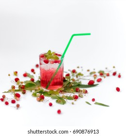 Strawberry lemonade in a glass with a tubule on a white background and with composition from a wild strawberry and leaves