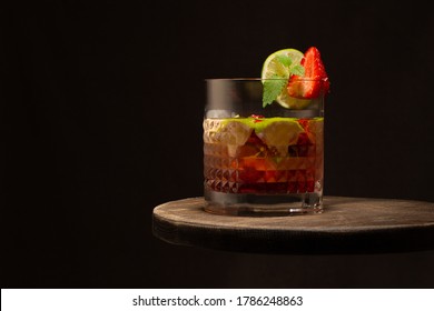 Strawberry And Lime Coktail In Crystal Glass With Ice Cubes And Mint Leaves On Wooden Table.Close Up.