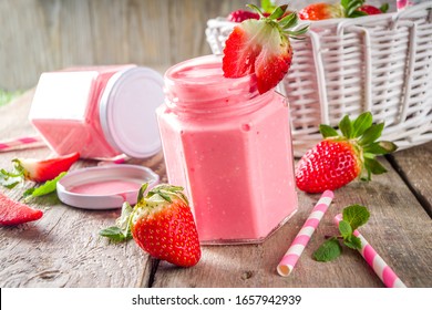 Strawberry milkshake in bottles, with fresh strawberries and mint on sunlight summer wooden and glass background, copy space - Powered by Shutterstock