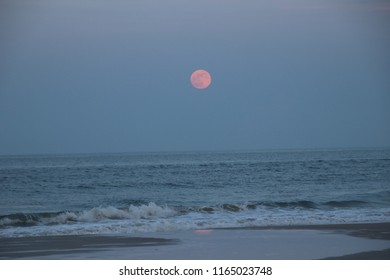 Strawberry moon over beach on summer night.
