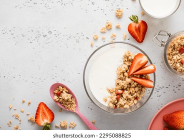 Strawberry organic granola with milk and pink spoon on light kitchen board. Top view. - Powered by Shutterstock