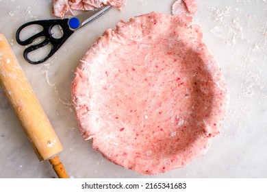 Strawberry Pie Crust Layered into a Deep Dish Pie Pan: Unfilled raw pink strawberry pie crust
