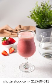 Strawberry Protein Shake In Glass. Raw Strawberries Blended With Protein Powder And Water Served In Glass. Raw Berries, Clean Water, White Kitchen Background.