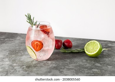 Strawberry And Rosemary Pink Gin Cocktail, Refreshing Alcohol Drink With Ice And Lime. Copy Space.