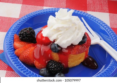 Strawberry Shortcake On A Picnic Table With Blackberries And Blueberries