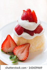 Strawberry shortcake on a white plate. Very shallow depth of field.