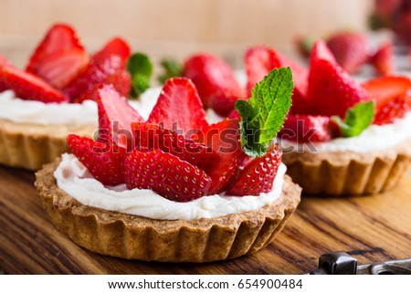Strawberry shortcake pies on rustic wooden table,  perfect party individual fresh fruit dessert 