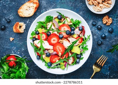 Strawberry, shrimp and herbs healthy salad with arugula, avocado and onion, blue kitchen table. Fresh useful dish for healthy eating - Powered by Shutterstock