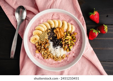 Strawberry Smoothie Bowl Loaded with Healthy Toppings: Fruit smoothy bowl with sliced banana, seeds, nuts, peanut butter, and dark chocolate chips - Powered by Shutterstock