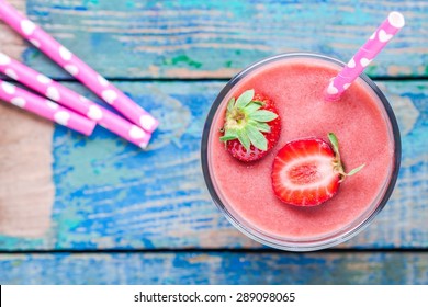 Strawberry Smoothie In A Glass With A Straw On A Wooden Table Top View