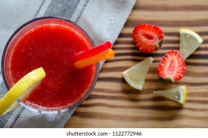 Strawberry Smoothie With Lemon And Straws On Wooden Table. Top View