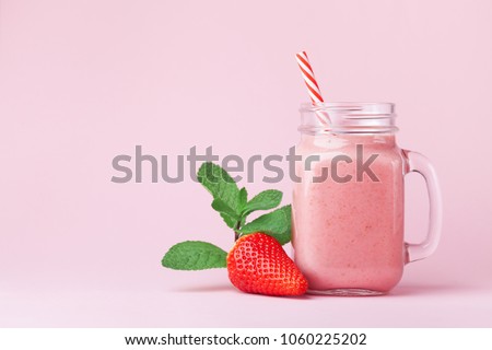 Strawberry smoothie or milkshake in mason jar decorated mint on pink table. Healthy food for breakfast and snack. Foto d'archivio © 