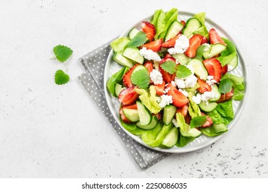 Strawberry spinach cucumber feta cheese salad. Top view, copy space, flat lay. - Powered by Shutterstock